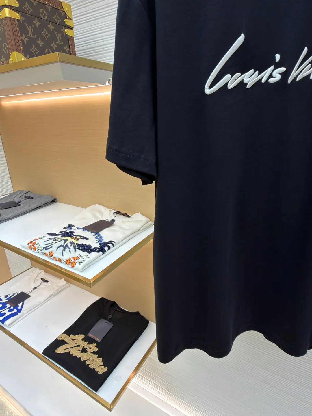 LOUIS VUITTON round neck short sleeves with hand lettering embroidery ●Item number: 1681408-X95 ●Material: long-staple cotton fabric ●Technology: embroidery production ●Color: black ●Version: fitted version ●Weight: about 230 grams ●Size: S-M-L-XL ●Description: Restore 60S single yarn double-sided long-staple cotton, weight 170g; with 32S 1×1 thread, 300g. After being treated with liquid ammonia, it looks like a water-gloss machine. The cloth surface is smooth and has a clear texture, with a slight luster and strong texture. The cotton fiber length of the fabric is long. The advantage of this feature is that after being spun into yarn, the surface of the yarn is smoother, less rough and has a delicate feel. The thin and long features give it a flexible texture, soft skin feel and fabric luster. The front side shows the thickness changes of 3D handwritten font embroidery handwriting strokes and the design pattern after the continuous strokes are simplified; the three-dimensional effect is achieved through multi-layer embroidery threads, filling materials and special stitching methods. Jagged edges are prone to appear on curves and corners; add foam embroidery to the bottom layer of the embroidery and then cut off the excess to form a three-dimensional bulge and improve the smoothness of the lines. Standard H hanging fit with shoulder-length design. The vertical version emphasizes that the width of the shoulders, waist, and hem are basically the same, and it is simple and loose. The short sleeves are tailored to fit the body of the wearer. At the same time, the neckline, cuffs and hem of the short sleeves are all designed with double lines. The overall wiring is straight and delicate, the fabric is comfortable and soft, and the color is consistent without color difference. It can be matched with the same style to create a fashionable look and control various occasions. Customized accessories, complete with three standards, same style for men and women!
